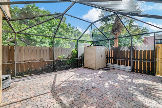 view of patio with glass enclosure and a shed