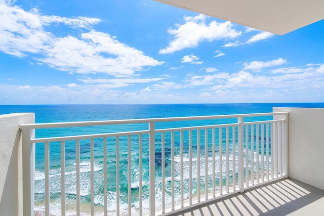 balcony featuring a water view and a view of the beach