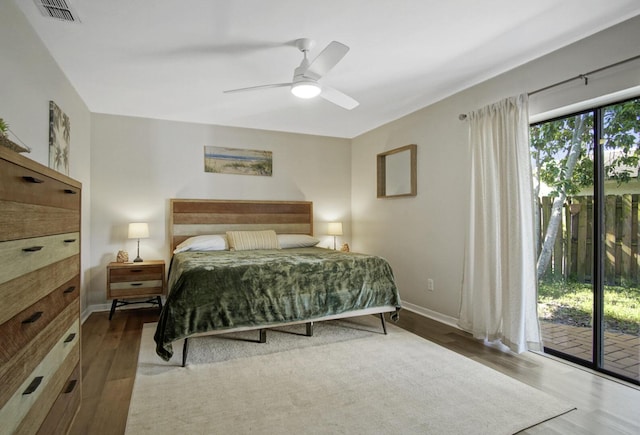 bedroom with baseboards, access to outside, visible vents, and wood finished floors