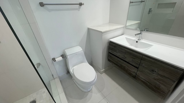 bathroom with a shower with door, vanity, toilet, and tile patterned floors