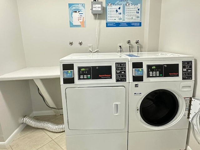 laundry room with light tile patterned flooring and washing machine and clothes dryer