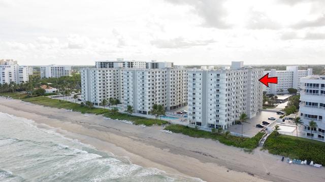 drone / aerial view featuring a water view and a beach view