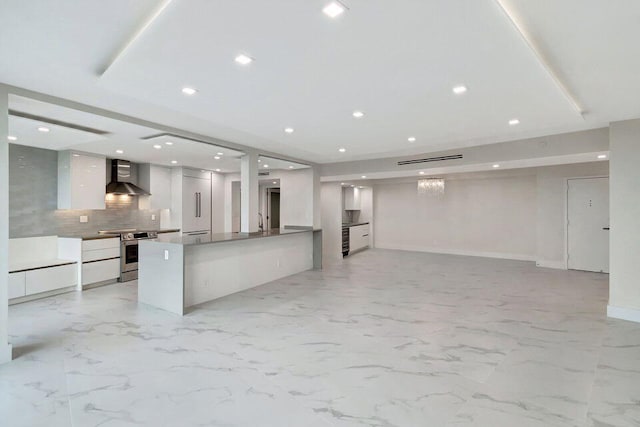 kitchen featuring white cabinetry, decorative backsplash, electric range, kitchen peninsula, and wall chimney exhaust hood