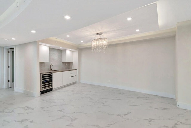 kitchen with pendant lighting, a notable chandelier, tasteful backsplash, white cabinetry, and wine cooler