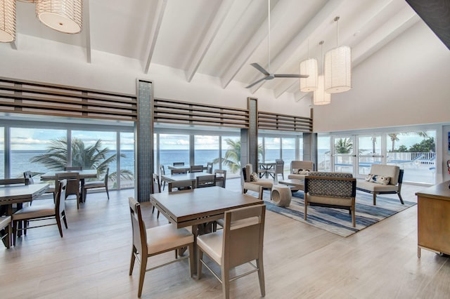 dining area with beamed ceiling, a water view, ceiling fan, high vaulted ceiling, and light hardwood / wood-style flooring