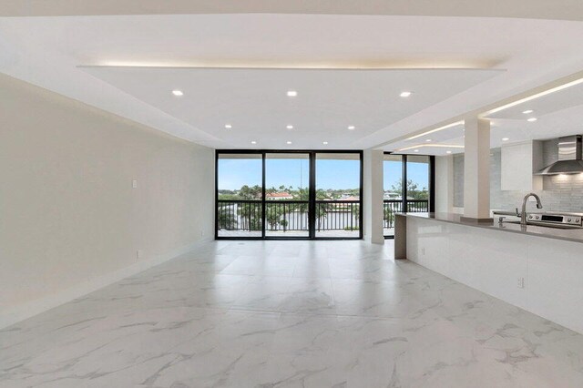 interior space featuring sink, a wall of windows, and a healthy amount of sunlight