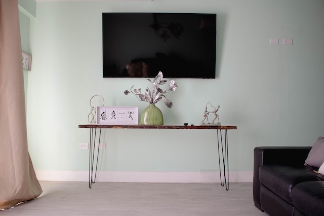 living room featuring hardwood / wood-style floors, a wall unit AC, and ceiling fan