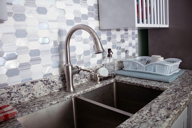 kitchen featuring white cabinets, light stone countertops, stainless steel appliances, and backsplash