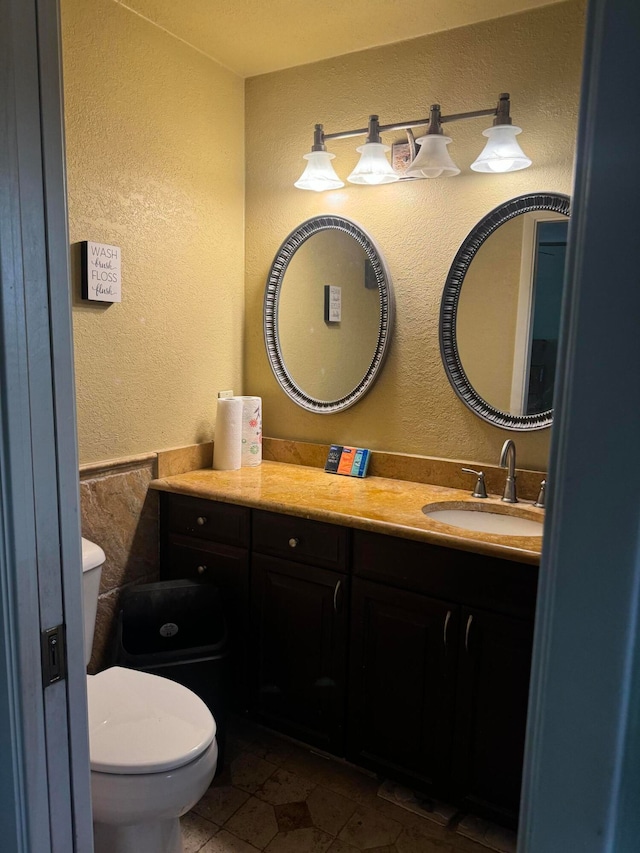 bathroom with tile patterned flooring, vanity, and toilet