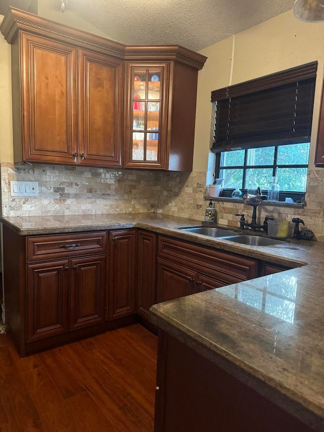 kitchen featuring decorative backsplash, a textured ceiling, dark hardwood / wood-style flooring, and sink