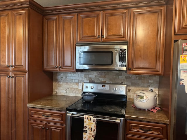 kitchen with backsplash, dark stone countertops, and appliances with stainless steel finishes