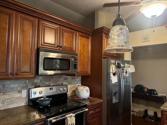 kitchen with decorative backsplash, pendant lighting, stainless steel appliances, and a textured ceiling