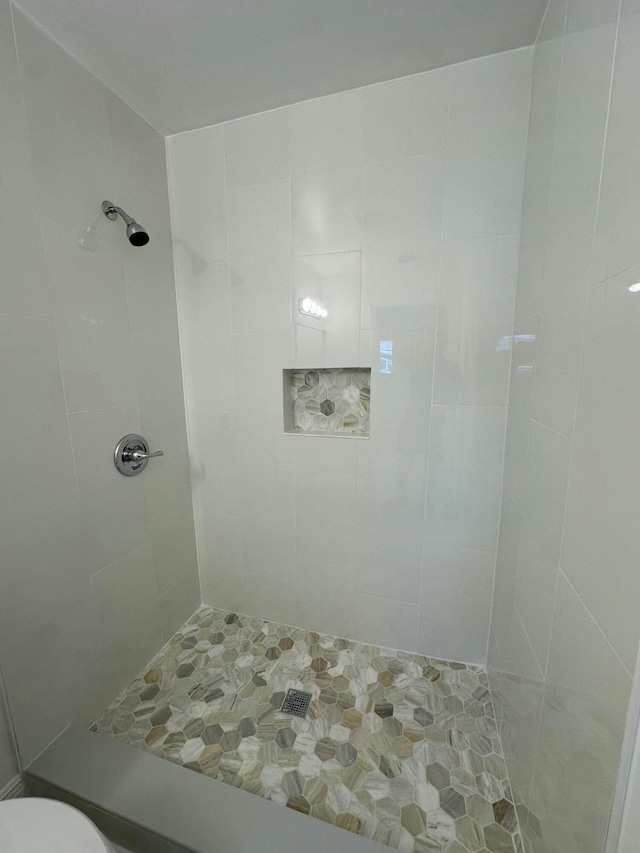 bathroom with toilet and tiled shower