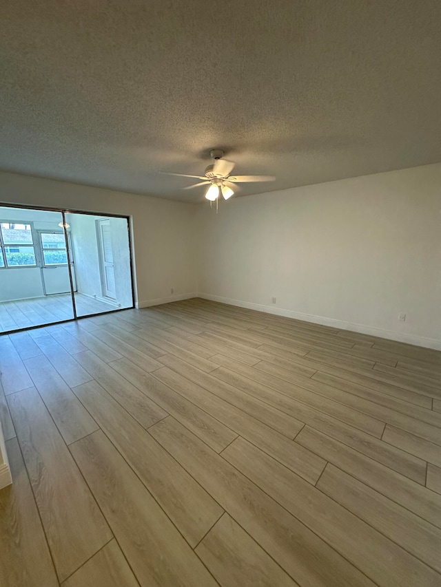 spare room with light hardwood / wood-style floors, a textured ceiling, and ceiling fan