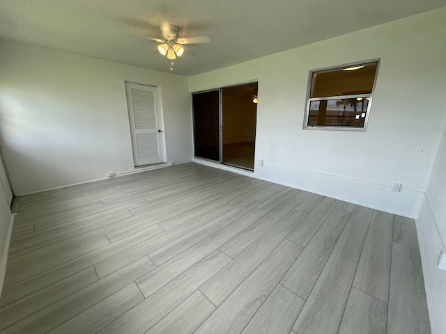 unfurnished room with a textured ceiling and light hardwood / wood-style floors