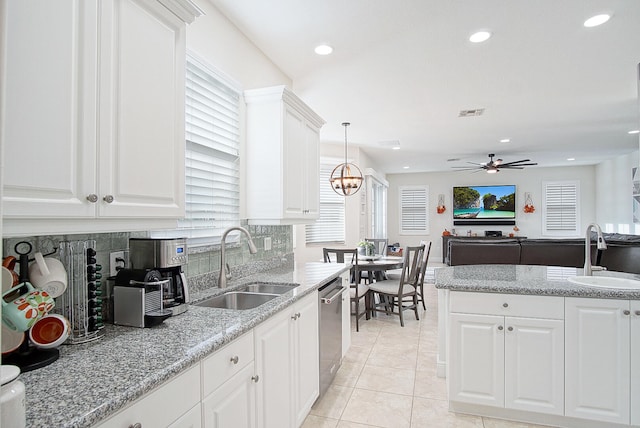 kitchen featuring white cabinetry, dishwasher, sink, and hanging light fixtures