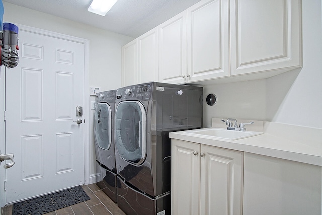 laundry room featuring cabinets, dark hardwood / wood-style floors, sink, and washing machine and clothes dryer