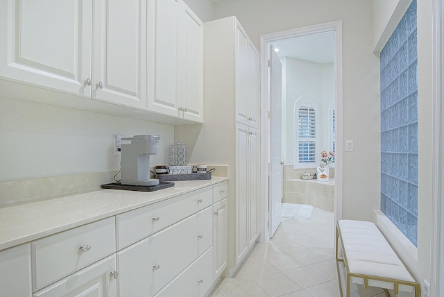 interior space featuring white cabinets and light tile patterned flooring