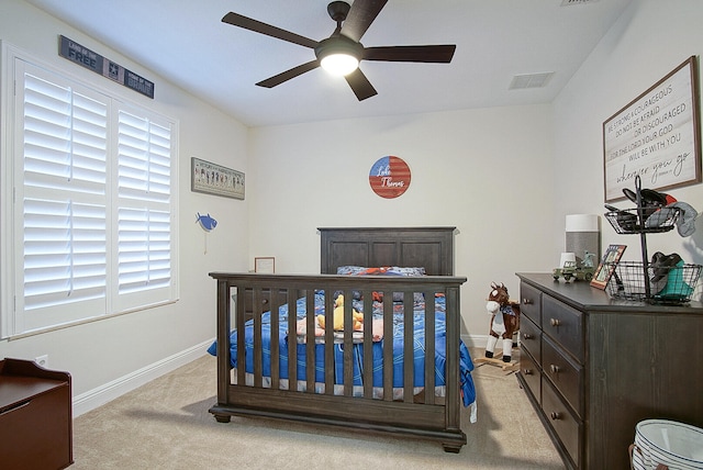 bedroom featuring multiple windows, light colored carpet, and ceiling fan