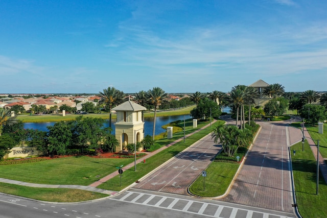 view of property's community with a yard and a water view