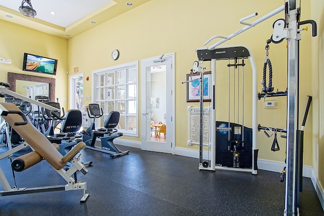 gym featuring a high ceiling and a raised ceiling