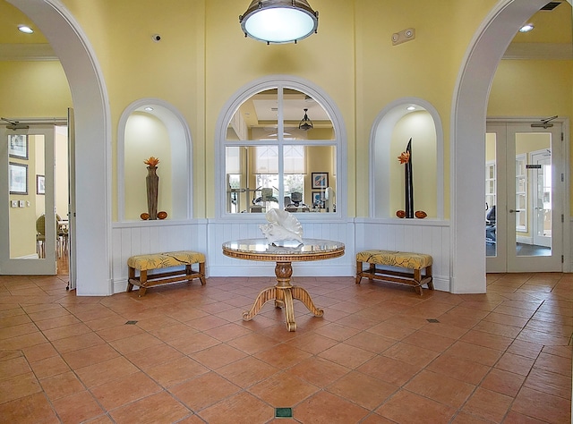 tiled entrance foyer featuring a towering ceiling, french doors, and ceiling fan