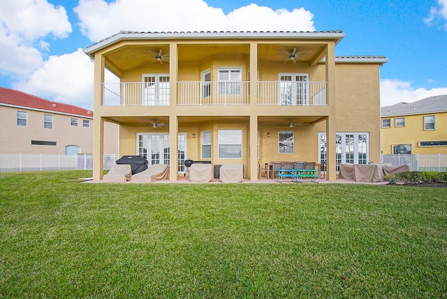 rear view of house featuring a patio area, a balcony, a yard, and ceiling fan