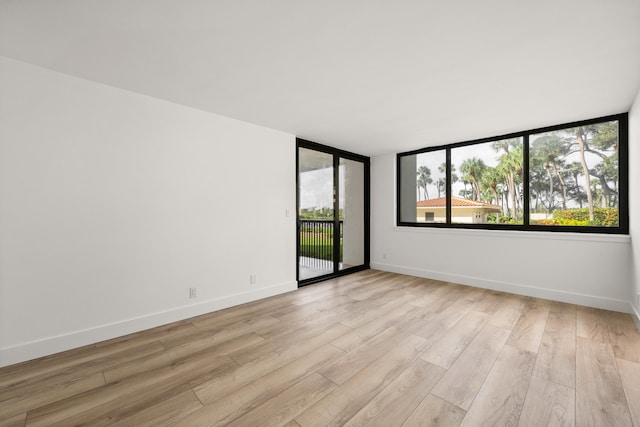 spare room with light wood-type flooring and baseboards