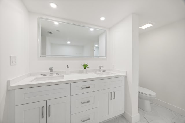 bathroom with recessed lighting, marble finish floor, a sink, and toilet