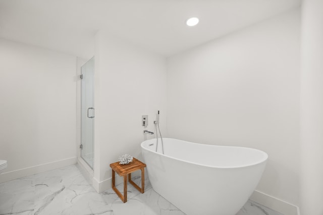 bathroom featuring marble finish floor, recessed lighting, a shower stall, a freestanding tub, and baseboards