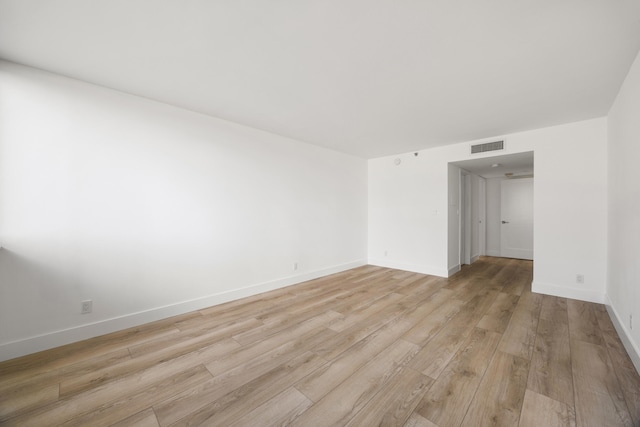 spare room with baseboards, visible vents, and light wood-style floors