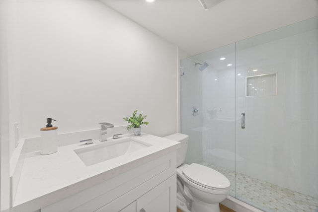 full bath featuring a stall shower, vanity, and toilet