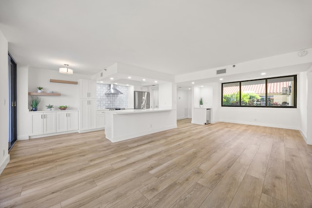 unfurnished living room with light wood-type flooring, visible vents, baseboards, and recessed lighting