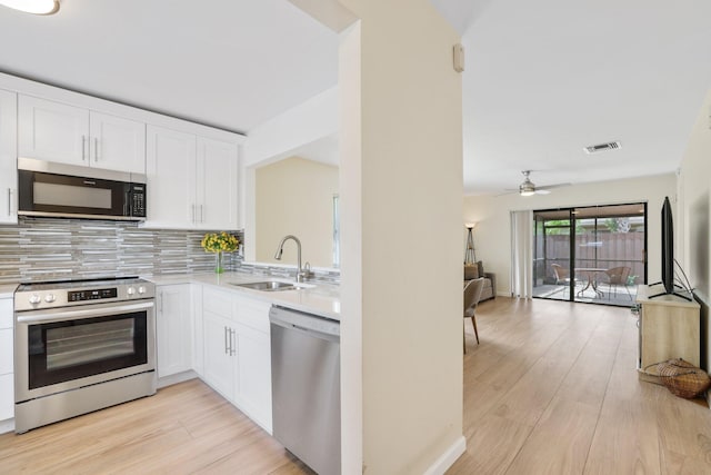 kitchen featuring sink, appliances with stainless steel finishes, light hardwood / wood-style flooring, and white cabinetry