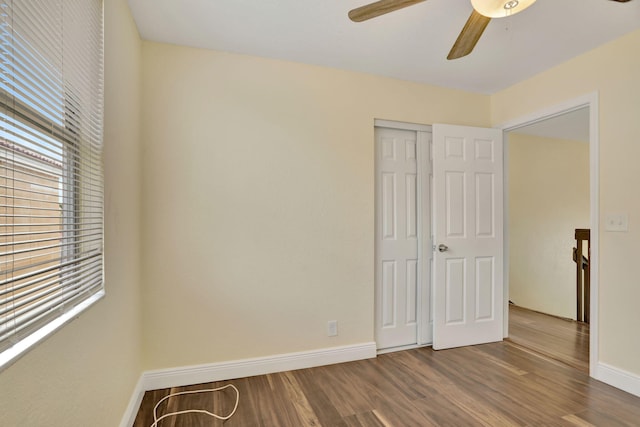 unfurnished bedroom with hardwood / wood-style flooring, ceiling fan, and a closet