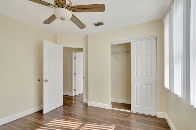 unfurnished bedroom with ceiling fan, a closet, and dark wood-type flooring