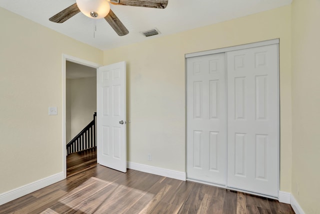 unfurnished bedroom with ceiling fan, a closet, and dark hardwood / wood-style floors