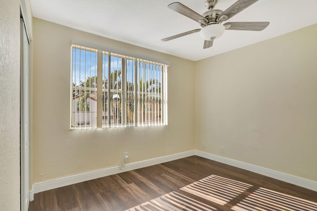 empty room with ceiling fan and dark wood-type flooring