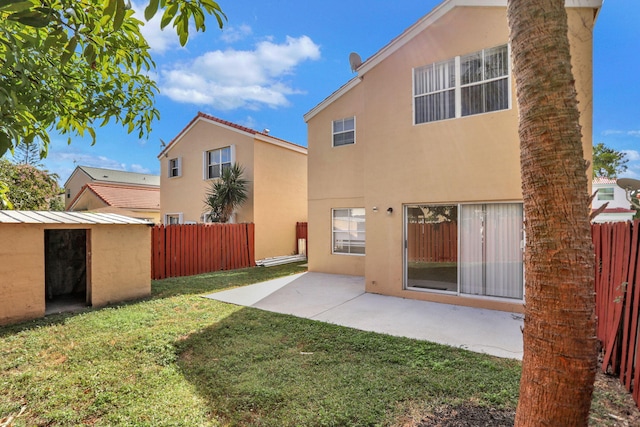 back of property featuring a patio area, a yard, and a storage shed