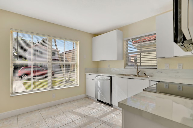 kitchen featuring dishwasher, white cabinets, sink, light stone countertops, and light tile patterned flooring