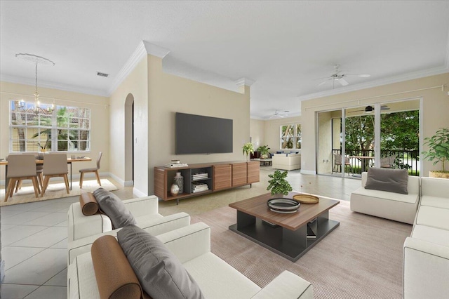 tiled living room featuring ceiling fan with notable chandelier, a healthy amount of sunlight, and crown molding