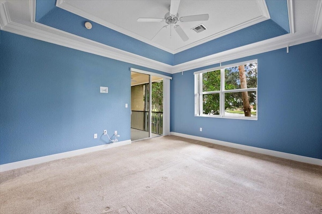 spare room featuring light colored carpet, a raised ceiling, ceiling fan, and ornamental molding