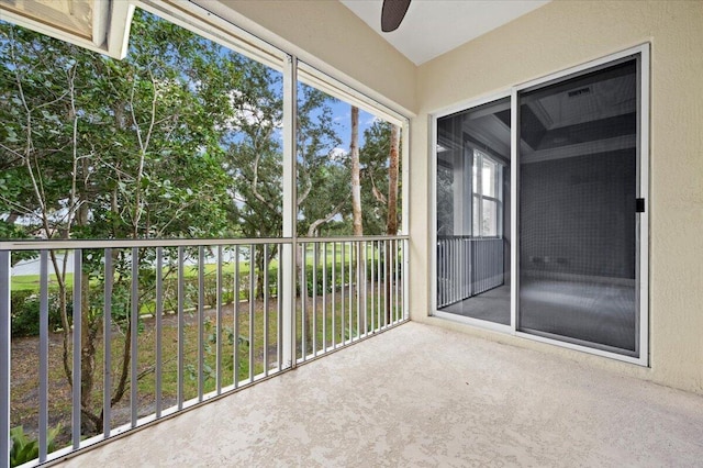 unfurnished sunroom featuring ceiling fan