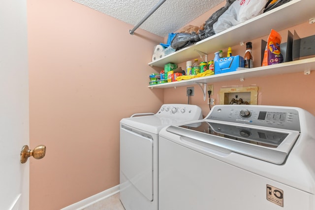 clothes washing area with a textured ceiling and washing machine and dryer