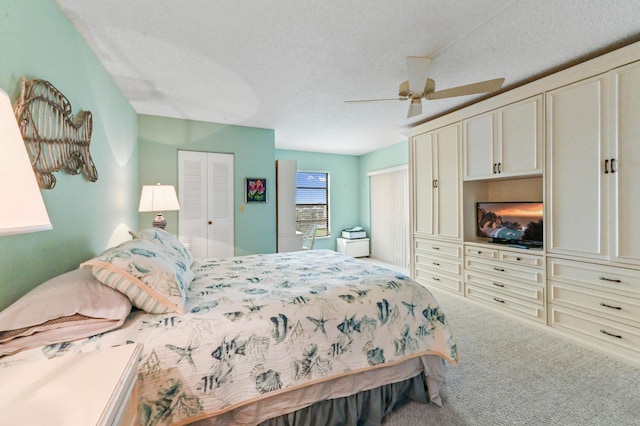 carpeted bedroom featuring a textured ceiling and ceiling fan