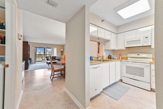 kitchen featuring white cabinets, white appliances, and sink