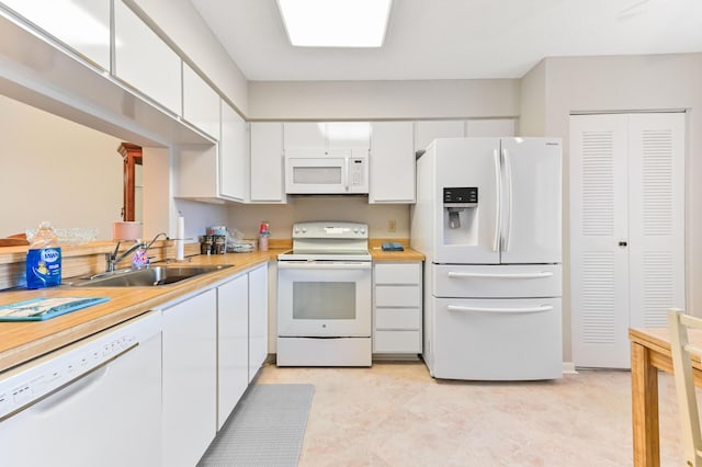 kitchen featuring sink, white cabinetry, and white appliances