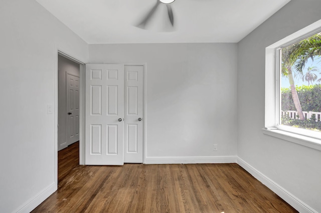 unfurnished bedroom featuring dark hardwood / wood-style flooring and a closet