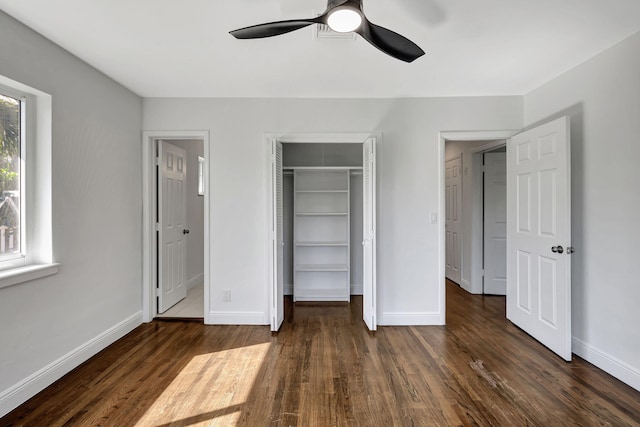 unfurnished bedroom featuring dark hardwood / wood-style floors, ceiling fan, and a closet