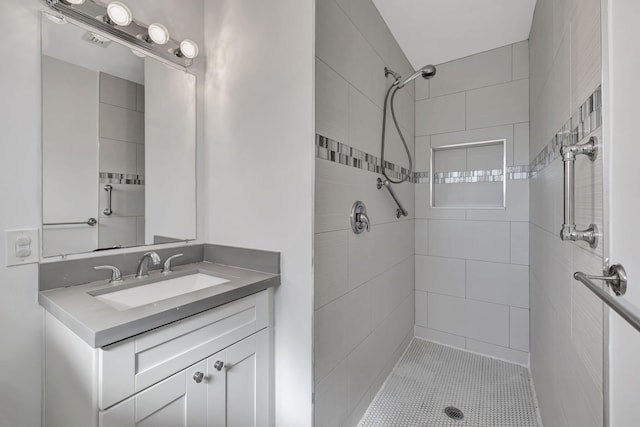 bathroom featuring tile patterned floors, vanity, and tiled shower